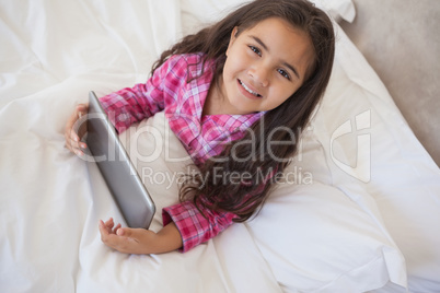 Young girl using digital tablet in bed