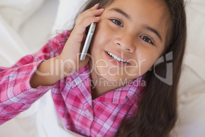 Young girl using mobile phone in bed