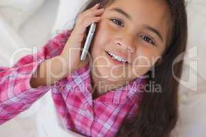 Young girl using mobile phone in bed