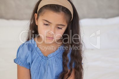 Close-up of a sad girl sitting on bed