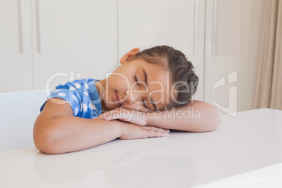 Cute young girl resting head on table