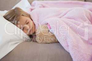 Close-up of a girl sleeping on sofa with stuffed toy