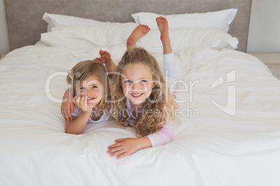 Smiling young kids lying in bed