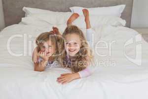 Smiling young kids lying in bed