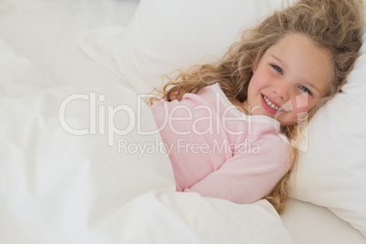 Smiling young girl resting in bed Smiling young girl resting in bed