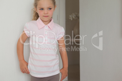 Serious girl standing against wall