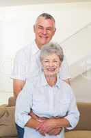 Retired couple embracing and smiling at camera