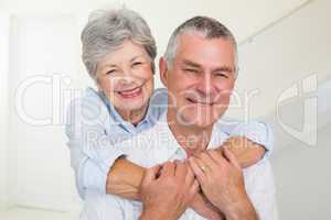Affectionate retired couple smiling at camera