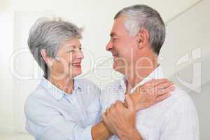 Affectionate retired couple smiling at each other