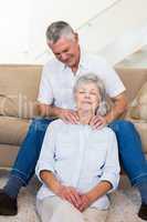 Man giving his relaxed senior wife a shoulder rub