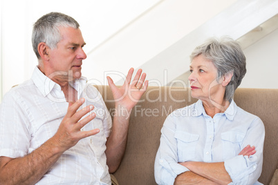 Senior couple sitting on couch having an argument