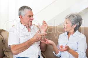 Senior couple sitting on couch having an argument
