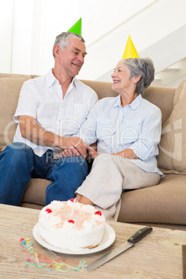 Senior couple sitting on couch celebrating a birthday