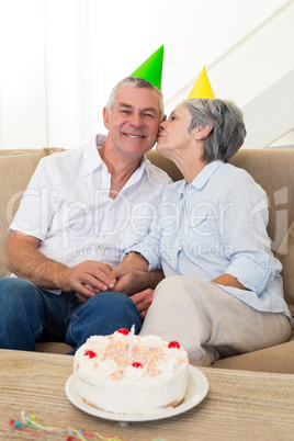 Senior couple sitting on couch celebrating a birthday