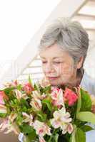 Retired woman smelling her bouquet of flowers