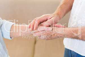 Retired couple touching hands