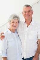 Happy retired couple standing and smiling at camera