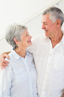 Happy retired couple standing and smiling at each other