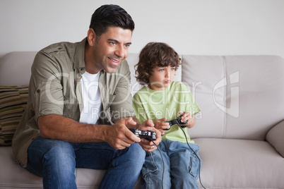 Father and son playing video games in living room