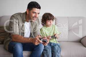 Father and son playing video games in living room