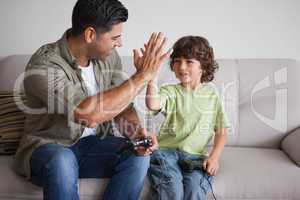 Father and son playing video games in living room