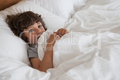 High angle portrait of a boy resting in bed