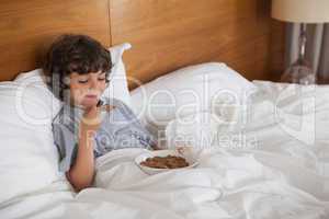 Young boy eating breakfast in bed