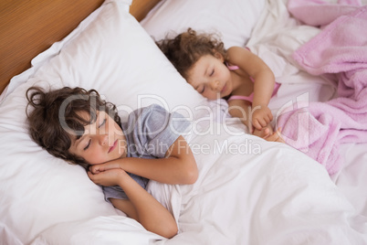 Young girl and boy sleeping in bed