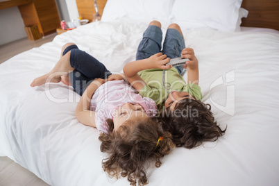 High angle of siblings resting in bed