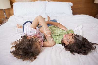 Happy siblings playing in bed