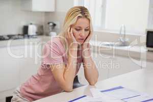 Unhappy woman with sitting in kitchen