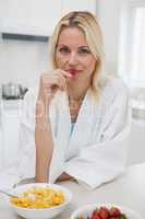 Portrait of a woman having breakfast in kitchen