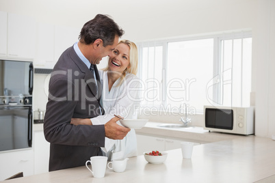 Woman embracing businessman in the kitchen