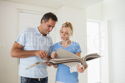 Couple looking at color book in house