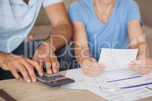 Mid section of a couple with bills and calculator