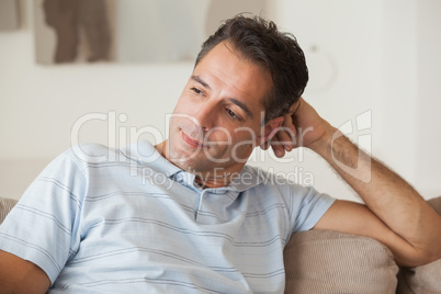 Close-up of a thoughtful man sitting on sofa