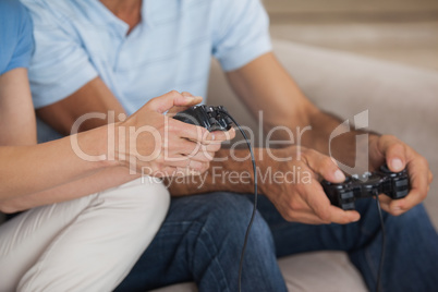 Close-up mid section of couple playing video games