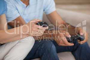 Close-up mid section of couple playing video games