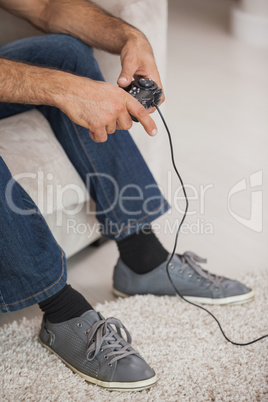 Low section of a man playing video games in living room