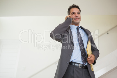 Smiling businessman using cellphone