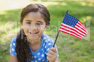 Young girl holding the American flag at park