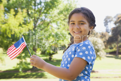Girl holding the American flag at park