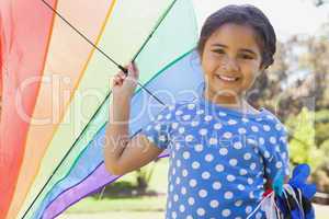 Happy young girl holding kite at park