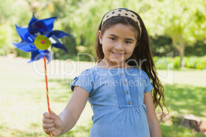 Cute little girl holding pinwheel at park