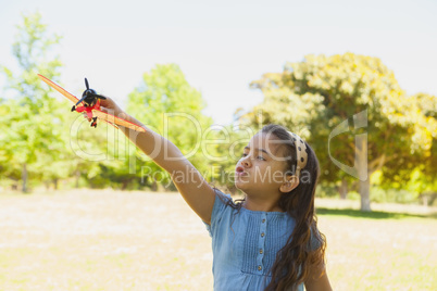 Girl playing with a toy plane at park
