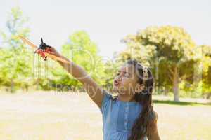 Girl playing with a toy plane at park
