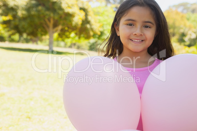 Portrait of a girl with pink balloons at park