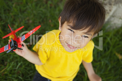 Young boy playing with a toy plane at park