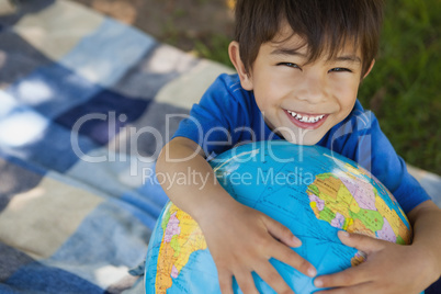 Close-up portrait of a cute boy holding globe