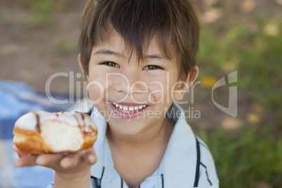 Happy young boy hyolding burger at park